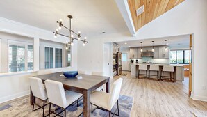 Una cocina moderna con una isla central, electrodomésticos integrados e iluminación colgante.