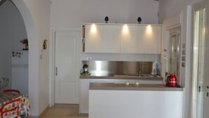 A compact kitchen with white cabinets, a stainless steel sink, and a wooden ceiling. - Villa Paola - Fontane Bianche (Fontane Bianche)