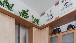 Una cocina moderna con armarios de madera, campana extractora de acero inoxidable, horno empotrado, lavavajillas y encimera de granito.