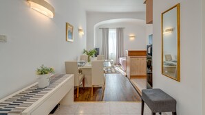 Una habitación de hotel moderna con comedor, una pequeña cocina y un espejo grande.