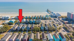An aerial view of a coastal residential area with colorful houses, a beach, and a pier. - 2nd Row, 4 BR Beach House with Community Pool! Endless Summer Nights (Surfside Beach)