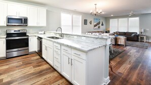 A modern kitchen with white cabinetry, stainless steel appliances, and a marble countertop. - 2nd Row, 4 BR Beach House with Community Pool! Endless Summer Nights (Surfside Beach)