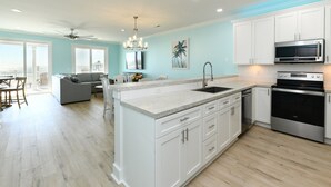 A modern kitchen with white cabinets, a granite countertop, and stainless steel appliances.