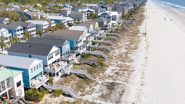 A coastal residential area with beachfront properties, including houses with balconies and beach access.