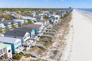 A coastal residential area with beachfront properties, including houses with balconies and beach access.