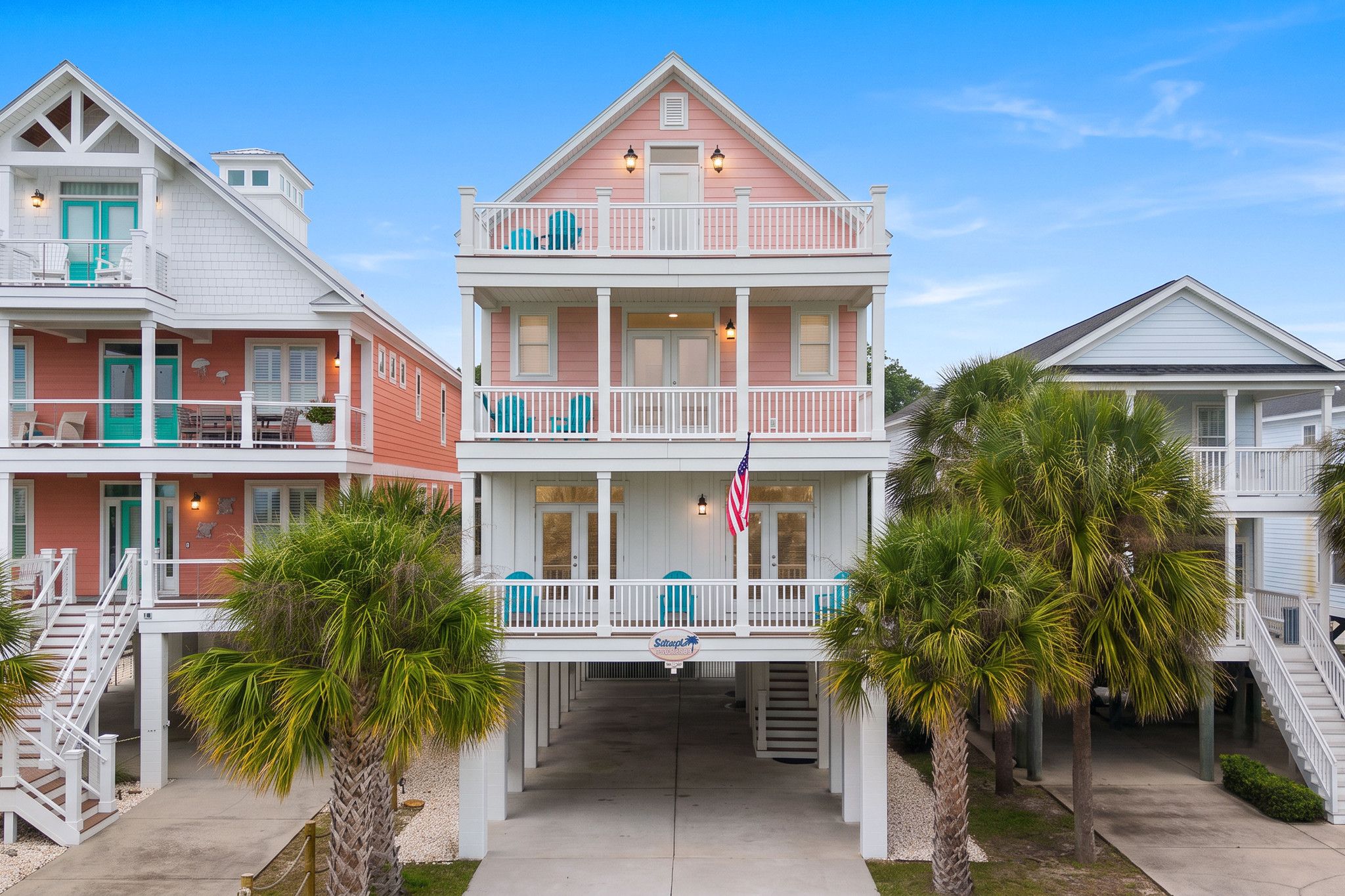 A beachfront property with a two-story building, a covered walkway, and a flag.