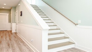 A staircase with white railings and wooden steps leading to a landing.