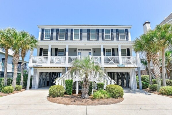 A two-story building with a balcony, palm trees, and a well-maintained lawn. - Oceanfront 6 BR with a Private Pool! Southern Belle (Garden City)