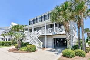 A two-story beachfront house with a balcony, palm trees, and a covered garage. - Oceanfront 6 BR with a Private Pool! Southern Belle (Garden City)
