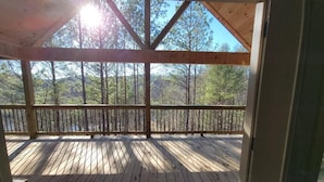 Eine Holzterrasse mit Blick auf einen Wald.
