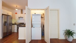 A compact kitchen with a refrigerator, stove, and washing machine.