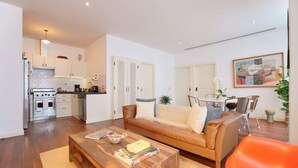 A modern apartment with a kitchen, dining area, and living room.