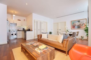A modern apartment with a kitchen, dining area, and living room.