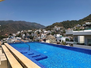 A swimming pool with a view of a hillside town.