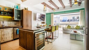 Eine moderne Küche mit Holzausstattung, einem eingebauten Ofen und einem Essbereich inklusive Sofa und Couchtisch.