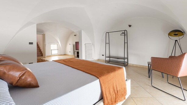 A bedroom with a bed, a chair, a standing lamp, and a wardrobe. - 2982 Porta Barocca by Barbarhouse (Lecce)