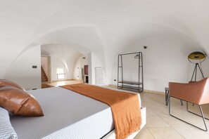 A bedroom with a bed, a chair, a standing lamp, and a wardrobe. - 2982 Porta Barocca by Barbarhouse (Lecce)
