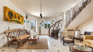 A spacious living room with a large painting, a wooden sofa, a glass coffee table, and a staircase. - 2260 Residenza Artistica - Villa Armida by Barbarhouse (Lecce)