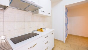 A modern kitchen with white cabinetry, a built-in stove, and a tiled backsplash. - Tribunali 194 - Cozy Flat in Center (Naples)