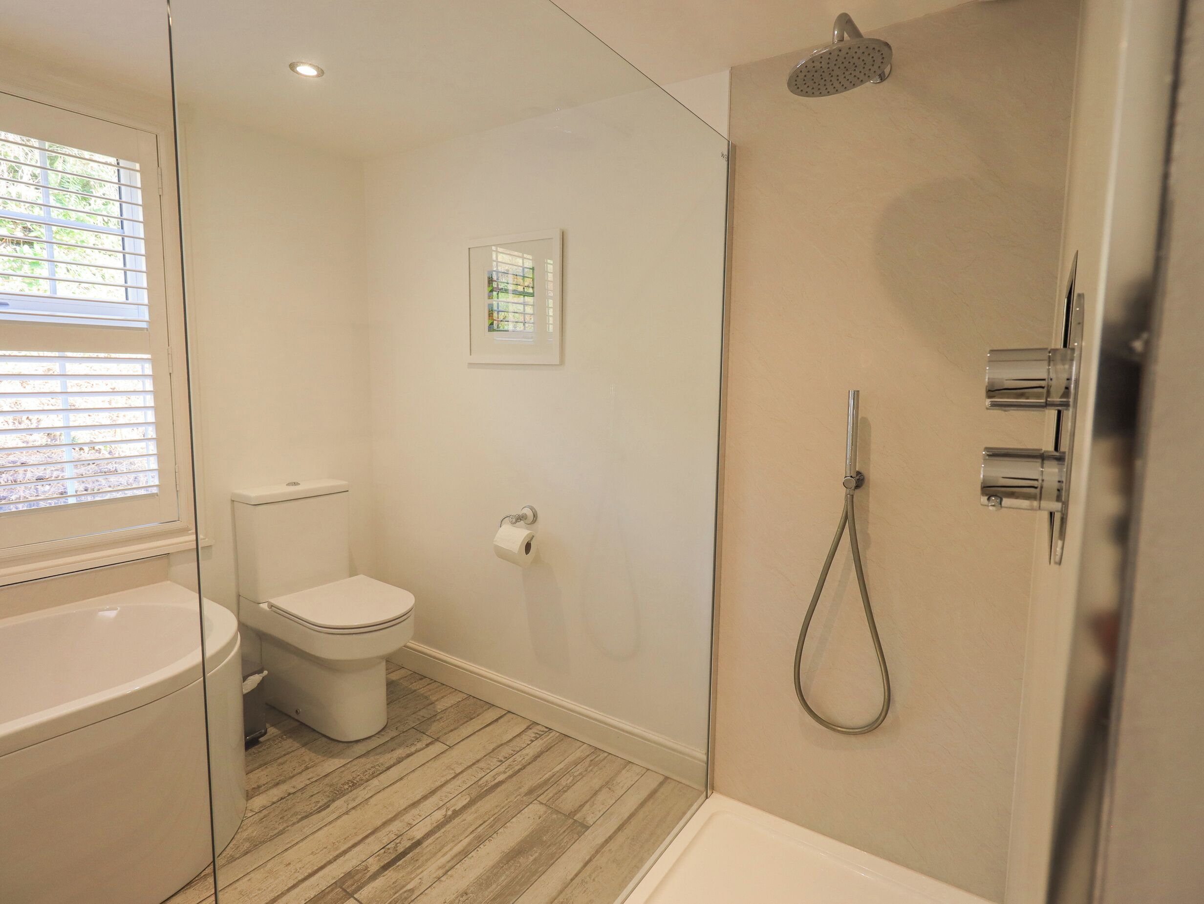 A bathroom with a toilet, a shower, and a bathtub.