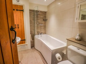 A modern bathroom with a bathtub, toilet, and shower. - Highfold (Ambleside)