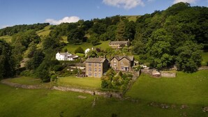 A rural house with a stone wall and a grassy yard. - Thyme Out (Windermere)