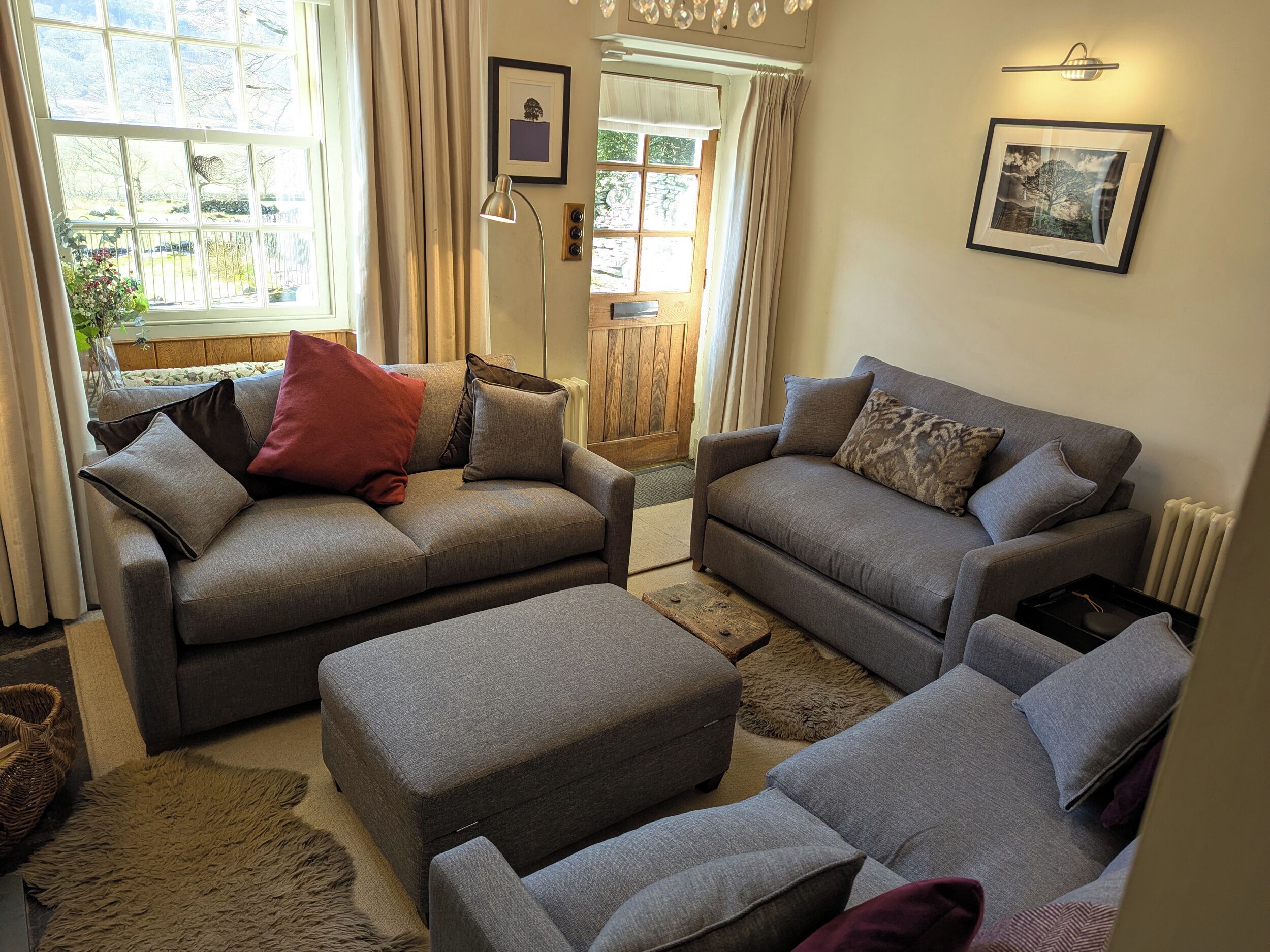 A living room with two grey sofas, a wooden coffee table, and a fluffy rug.