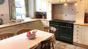 Une cuisine équipée d’une cuisinière, d’un four et d’une table à manger avec des chaises.