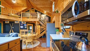 A wooden cabin interior with a kitchen, dining area, and a loft bedroom. - Cozy cabin located in Beavers Bend, close to Broken Bow lake, Casino (Broken Bow)