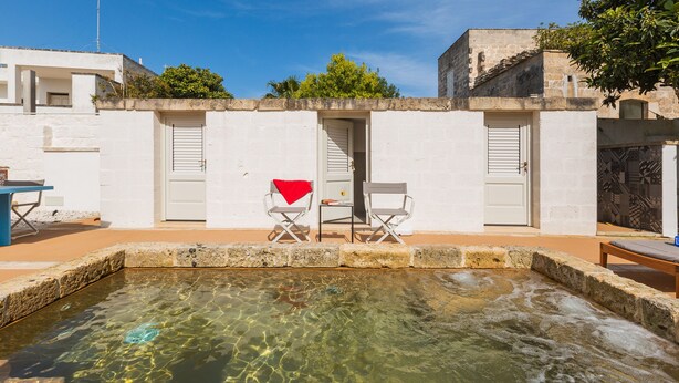 A swimming pool with clear water, two chairs, and a red towel. - 2320 Villa Ilse by Perle di Puglia (Andrano)