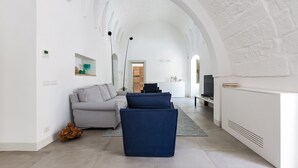 A modern living room with a sofa, a television, and a white fireplace. - 2320 Villa Ilse by Perle di Puglia (Andrano)