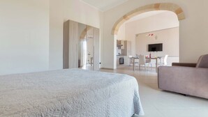 A spacious bedroom with a large bed, a sofa, and a kitchen area visible through an archway. - 2292 Villetta Cielo Blu by Barbarhouse (Lecce)