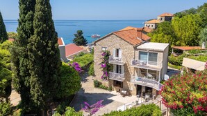 A coastal property with stone buildings, balconies, and a view of the sea. - Rooms Tupina By Paulina - Hostel (Zupa dubrovacka)