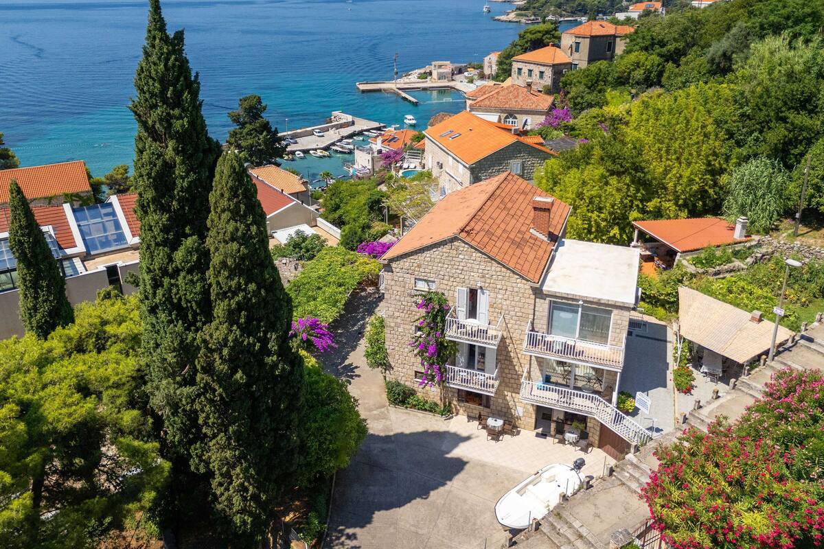A coastal town with stone buildings, a marina, and a clear view of the sea.