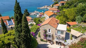 A coastal town with stone buildings, a marina, and a clear view of the sea.