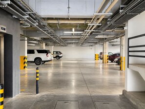 An underground parking garage with multiple levels, concrete floors, and cars parked.