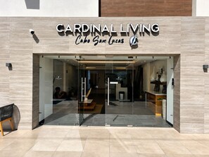 The entrance to Cardinal Living with a clear glass facade, a reception desk, and a seating area visible inside.