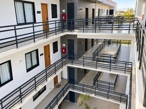 A multi-level building with balconies, staircases, and a view of the sea.