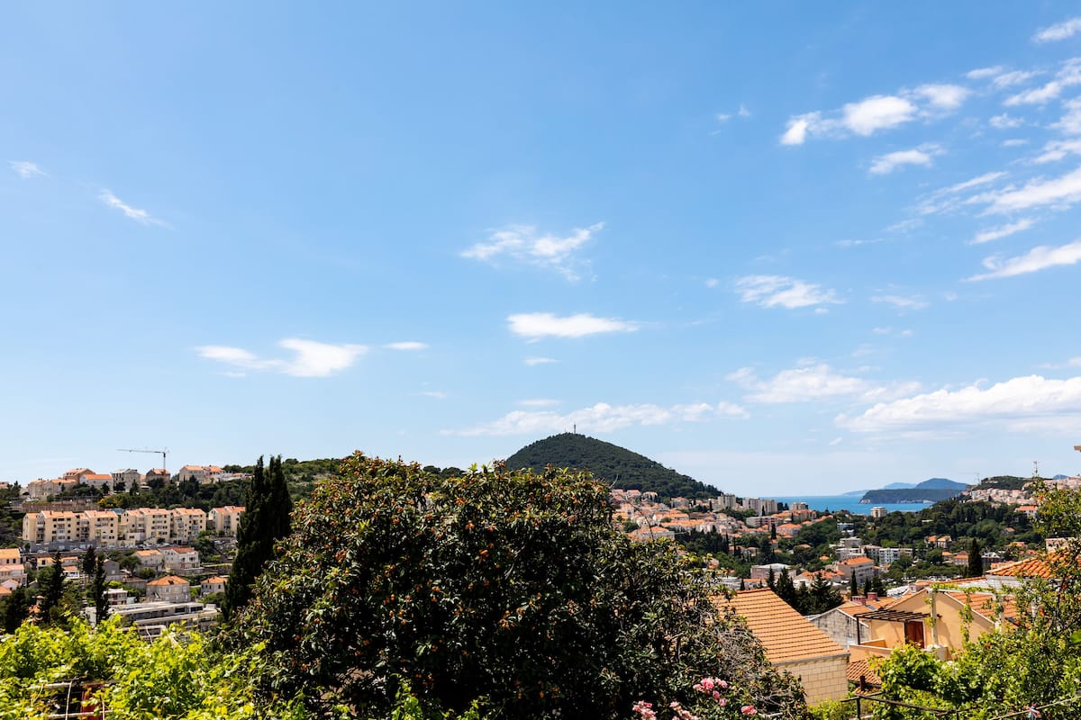 Une ville côtière avec des bâtiments, une colline et un ciel dégagé.