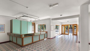 A spacious room with patterned flooring, a reception desk, and large windows. - 2507 Red Apartment by Barbarhouse (Vernole)