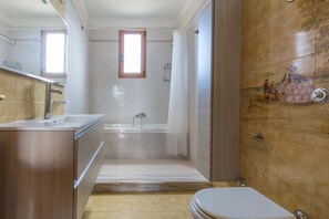Ein Badezimmer mit Badewanne, Dusche, Toilette und Waschbecken.