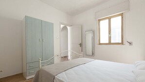 A bedroom with a bed, a wardrobe, a door leading to another room, and a window. - 2977 Villetta Idume by Barbarhouse (Lecce)