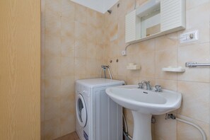 A compact bathroom with a washing machine, a sink, and a mirror above the mirror. - 2977 Villetta Idume by Barbarhouse (Lecce)