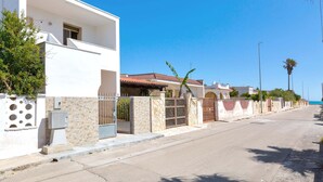 A residential street with modern houses, a gated entrance, and a clear blue sky. - 2977 Villetta Idume by Barbarhouse (Lecce)