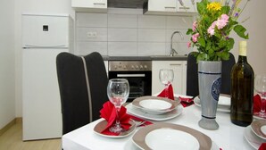 Uma mesa de jantar posta com pratos, copos e um vaso de flores.