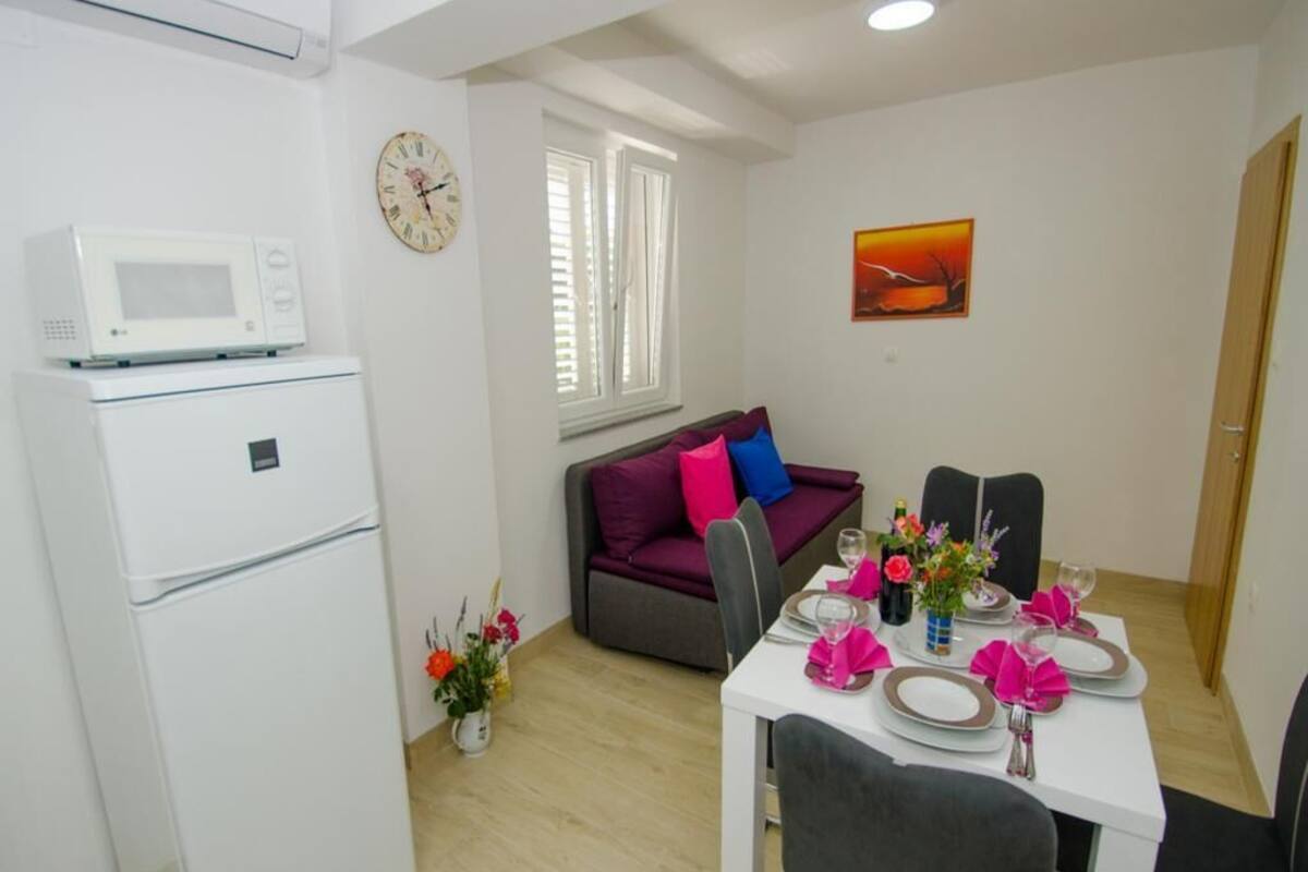 A compact living space with a kitchenette, a dining area, and a sofa.