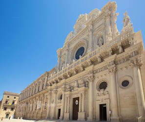 Un edificio imponente y ricamente decorado con detalles arquitectónicos intrincados, incluyendo columnas y estatuas.
