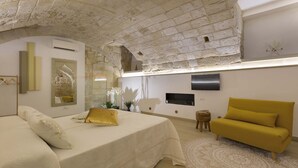 A bedroom with a bed, a sofa, a TV, and a decorative wall. - 2661 Porta del Duomo Luxury by Barbarhouse (Lecce)