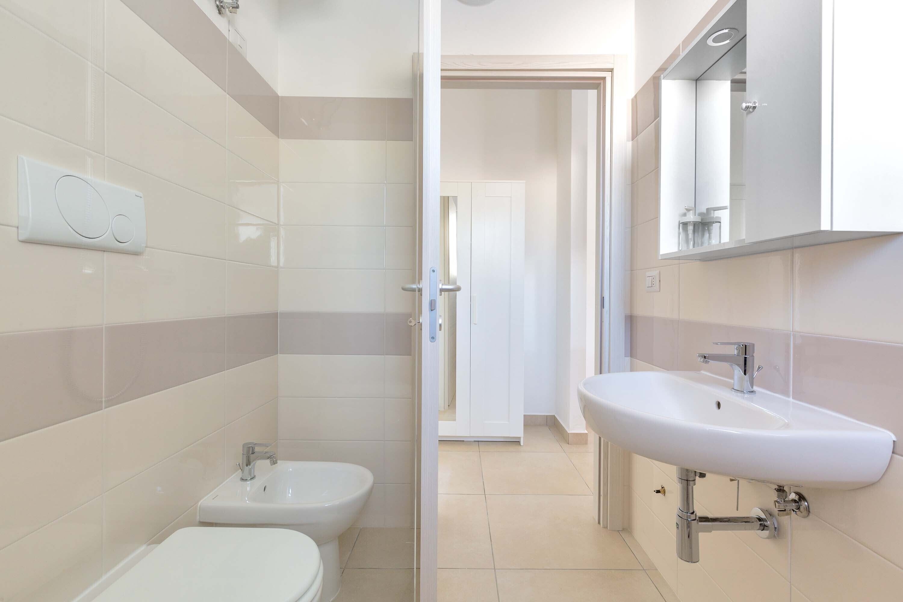 Un baño moderno con inodoro, bidé y lavamanos.