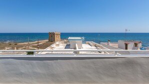 A coastal view with a clear sky, a tower, and a building with a flat roof. - 3096 Residence Marelena- Villino Tramontana by Barbarhouse (Squinzano)